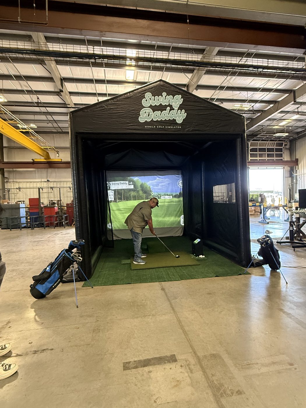 Guests engaging with the Swing Daddy mobile golf simulator at an Oklahoma community group event